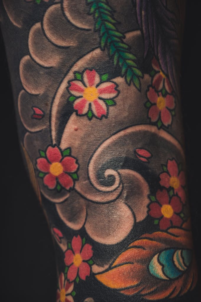 Vibrant floral tattoo on forearm with detailed color work and intricate patterns.
